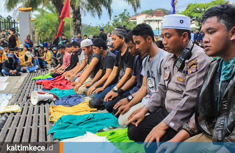 Momen salat berjamaah antara demonstran dan polisi. (Wahyu Musyifa/kaltimkece.id)